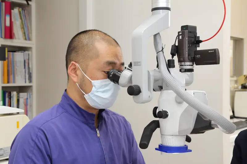 マイクロスコープを用いて微細な細菌の取り残しを防いでいます