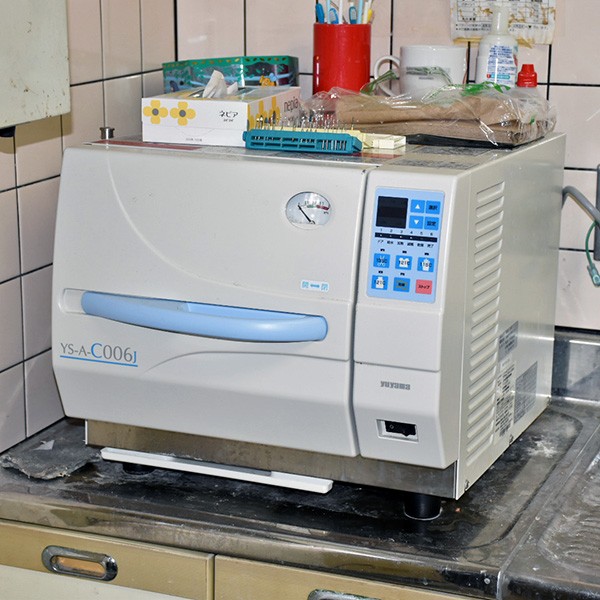 高圧蒸気滅菌機によって治療器具を滅菌しています